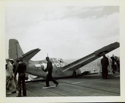 Photograph, Crashed FM2 aircraft looking across deck of U.S.S. Rudyerd Bay (CVE-81)
