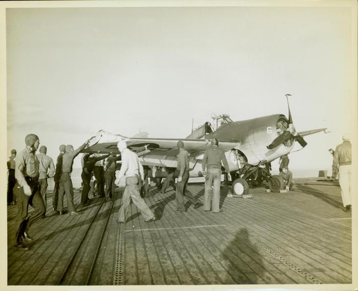 Photograph, FM1 damaged in barrier crash aboard U.S.S. Casablanca, Pilot Ens. Robert K. Lohman