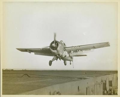 Photograph, Grumman FM1 Wildcat over flight deck of U. S. S. Casablanca, Robert K. Lohman, Ens. Pilot