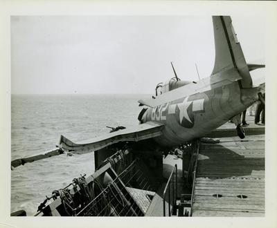 Photograph, Crashed FM2 aircraft aboard U.S.S. Rudyerd Bay, port side catwalk looking forward