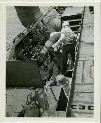 Photograph, Sailors aboard the U.S.S. Rudyerd Bay tending to a seaman injured in the crash of an FM2 aircraft.