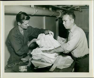 Photograph, Sailors packing parachute aboard U. S. S. Rudyerd Bay