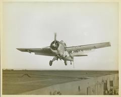 Photograph, Grumman FM1 Wildcat over flight deck of U. S. S. Casablanca, Robert K. Lohman, Ens. Pilot