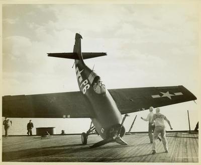 Photograph, FM1 aircraft damaged in barrier crash aboard U.S.S. Casablanca, Pilot Ensign Robert K. Lohman