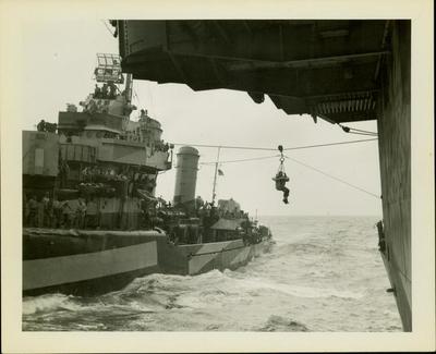Photograph, A sailor being highlined from ship to ship.