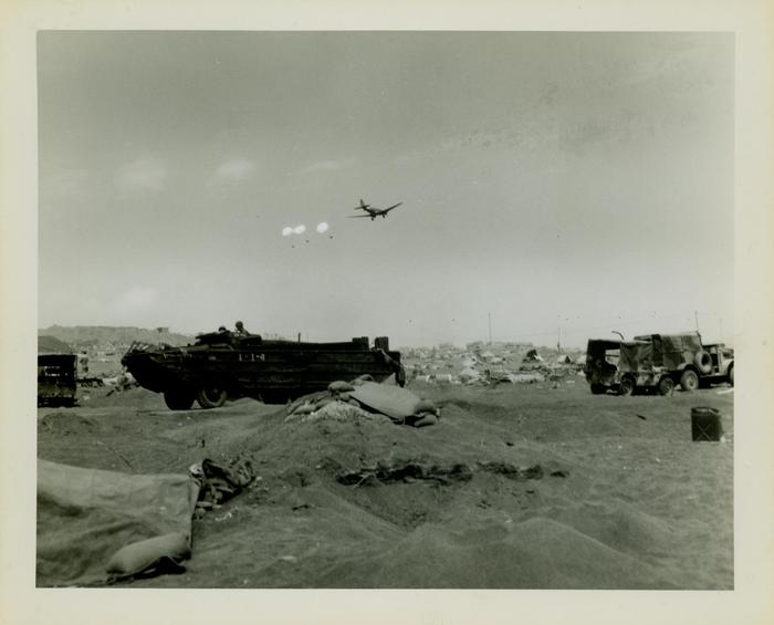 Photograph, Supply plane parachuting supplies over the beach at Iwo Jima